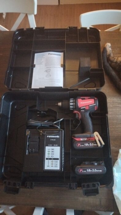 Ny Panasonic skruvdragare i fodral med tillbehör, inklusive batterier och laddare, på ett bord.