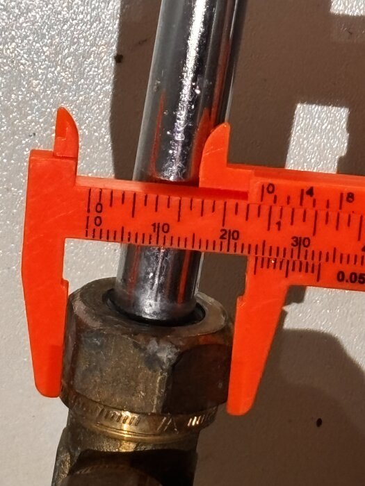 Rör mätas med ett skjutmått för att planera installation av avstängningsventil i ett byggprojekt.