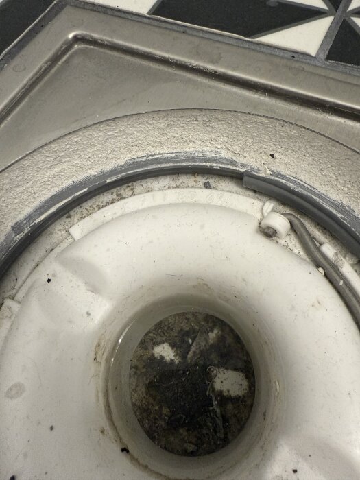 Golvbrunn med smuts och tecken på slitage, del av badrumsrenovering. Frågeställning om installationens kvalitet.