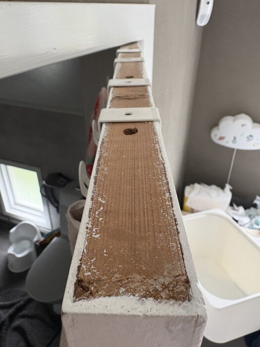 Närbild på dörrens överkant med synligt träverk, vilket indikerar en eventuell spegeldörr med monterad skiva ovanpå.