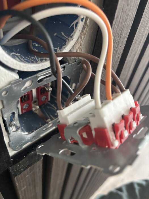 Anslutningskablar i ett vägguttag med vita komponenter, samtal kring byte till svart komponent.
