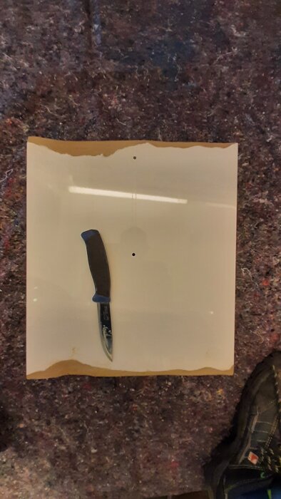 Sliten skåplucka i MDF som repareras med kniv och kemiskt trä.