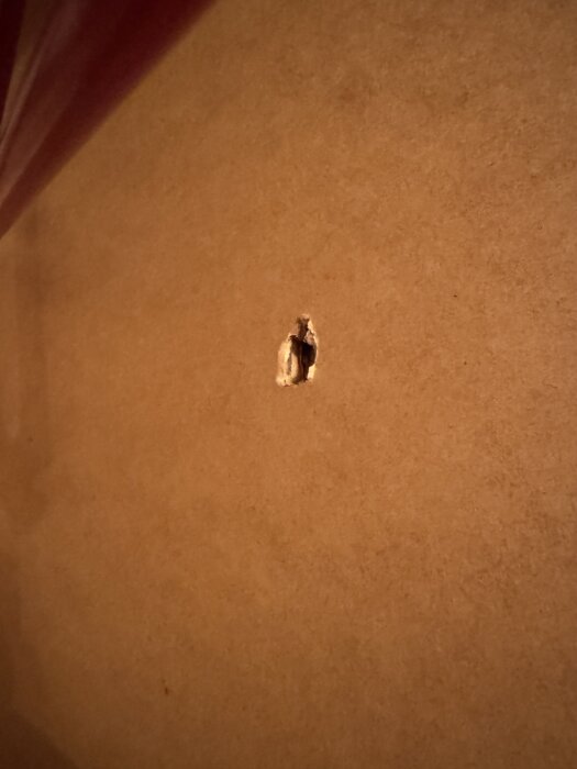 Hål i tunn MDF-skiva, del av försök att montera hyllplan i 60-70-tals skåp. Skruv och plugg användes, men strukturen höll endast hyfsat.