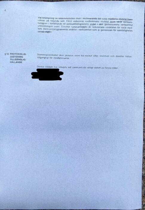 Bild av en sida från ett stadgedokument där delar av texten är överstrukna och ett textblock är svartmarkerat för att dölja innehåll.