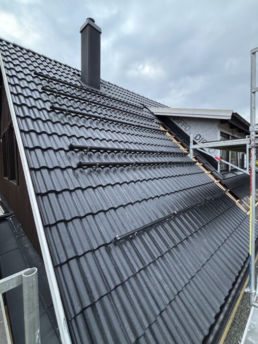 Tak med monterade solpanelskenor och ställning synlig, förberett för installation av solceller på ett 45-gradigt tak.