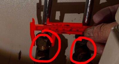 En närbild av två rördelar, en person mäter avståndet med en röd linjal. Två cirklar markerar möjliga T-rör med förminskning.