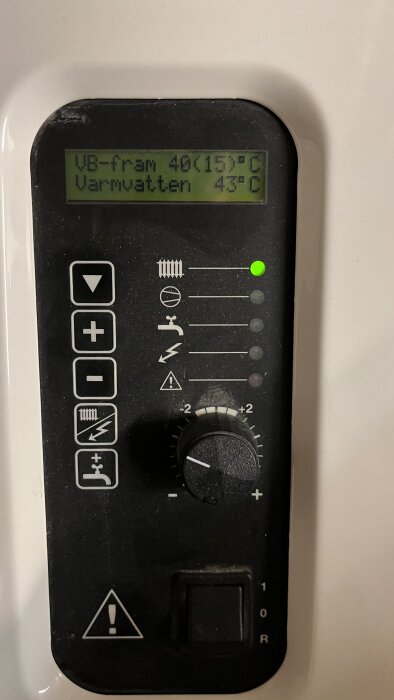 Kontrollpanel för uppvärmning med display som visar "VB-fram 40(15)°C, Varmvatten 43°C", och knappar för justering.