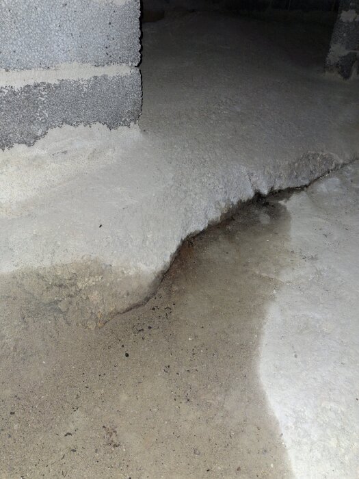 Spricka i berghäll med fuktgenomträngning i en krypgrund, del av byggprojekt.