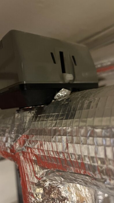 Grå kompressor med metallisk isolering syns.