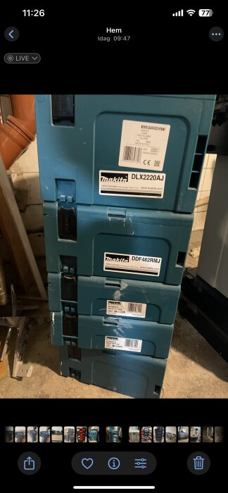 Staplade Makita verktygsförvaringslådor märkta med DLX2220AJ och DDF482RMJ, på ett golv i en verkstadsmiljö.