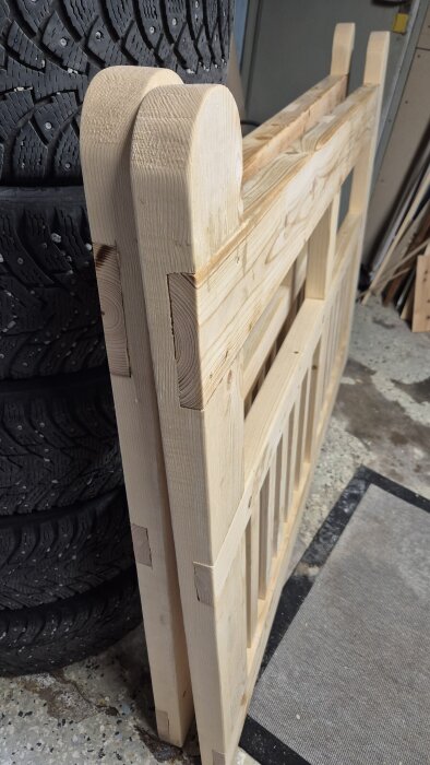 Trägrindar i ljust trä lutade mot däck, visar snickeridetaljer och träets struktur, med synliga fogar som behöver kompletteras.