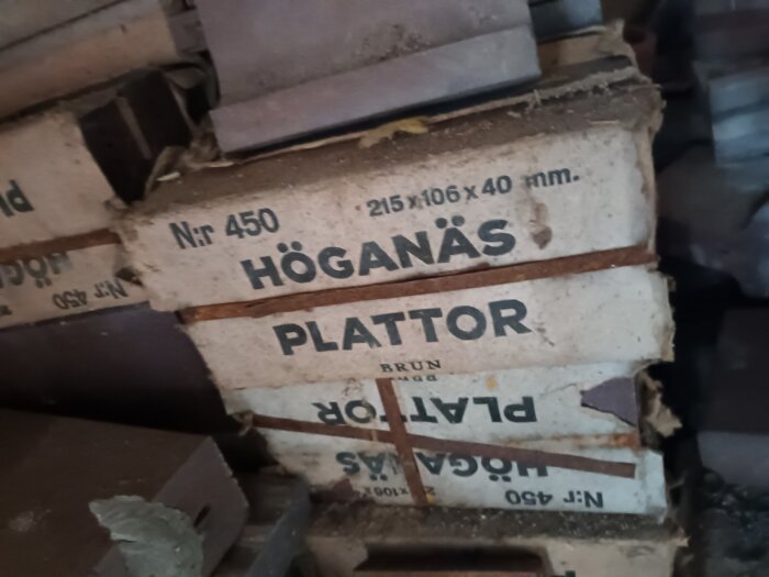 Förpackningar med Höganäs golvklinker av modell Nr 450, brun färg, mått 215 x 106 x 40 mm staplade på varandra.