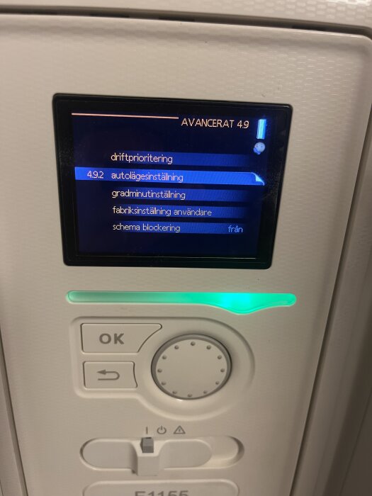 Närbild av Nibe 1155 bergvärmepumpens display med avancerade inställningar, inklusive autolägesinställning och schema blockering.