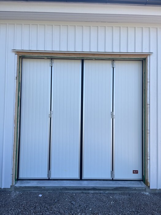 Fyra inåtgående skivdörrar monterade, del av bygge med takskjutsport.