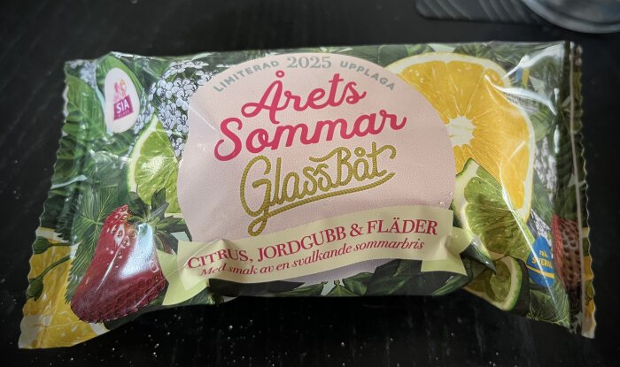 Förpackning av glass med trycket "Årets Sommar Glassbåt" och smaker av citrus, jordgubb och fläder, från SIA Glass, begränsad upplaga 2025.