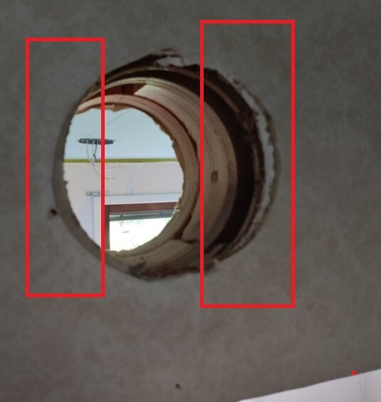 Runt hål i en vägg med inblick till bakomliggande rum, visar konstruktion av brädbitar runt och bakom hålet.