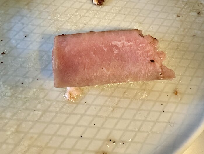Bit av tonfisk på ett fat, del av en grillad måltid med färskpotatis.
