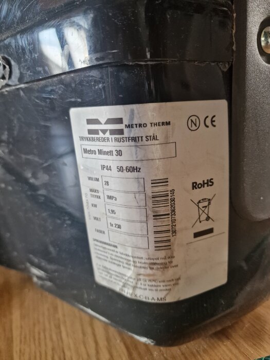 Etikett på en Metro Therm varmvattenberedare, modell Metro Minett 30, med specifikationer som 28 liter volym och 1,95 kW effekt.