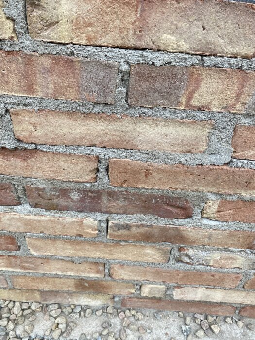 Tegelvägg med ojämna fogar. Muren är 60 cm hög med murbruk C. Fogarna sluter inte tätt mot tegelstenarna.