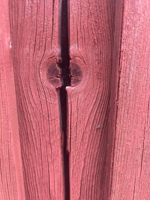 Sprucken lockpanel i rödbrun färg med tydliga ådringar och en knut.