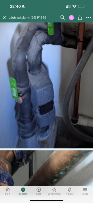 Inslagna rör med gröna etiketter på påfyllnadsventil, troligen ett filter.