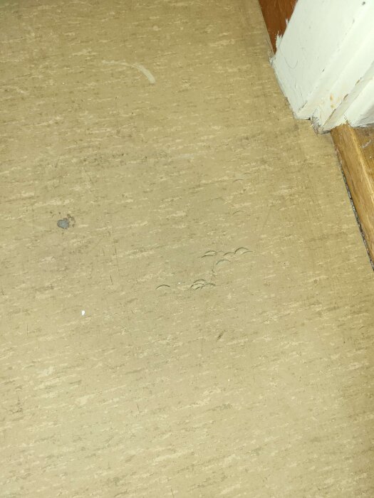 Golvet i en garderob med fläckar och märken, del av ett potentiellt linoleumgolv från 60-talet, möjligtvis med risk för asbest.