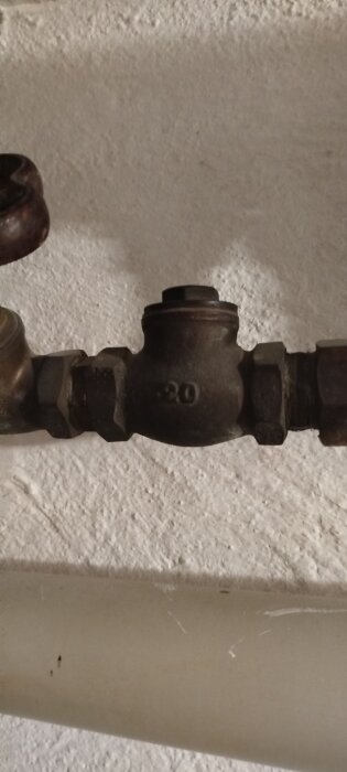 Metallisk komponent i vattenburet system, potentiellt filter eller backventil.