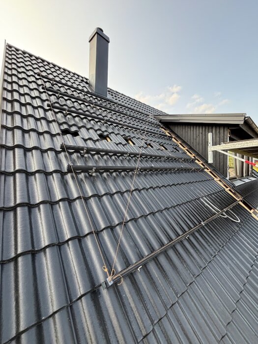 Tak med solcellsskenor och murarsnöre för planhet, med panel och flexslangar monterade på tillbyggnadens kupa.