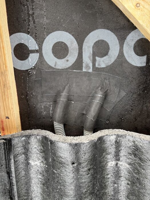 Flexslangar genom tak med tätningstejp ovanför en takpanna, del av solcellsinstallation.