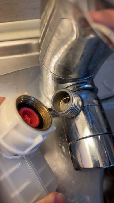 Närbild av en köksblandare och en diskmaskinslang som inte passar, med fokus på gängorna där en övergångsnippel behövs.