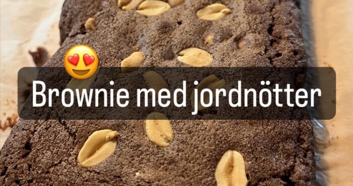 Brownie med jordnötter på skärbräda, text över bilden lyder "Brownie med jordnötter" och emoji med hjärtögon.