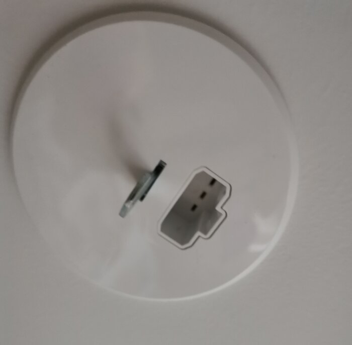 DCL-uttag i vitt tak med synlig kontakt i närbild, för montering av tung taklampa.