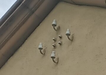 Flera rörledningar och anslutningar på en betongvägg vid ett pumphus.