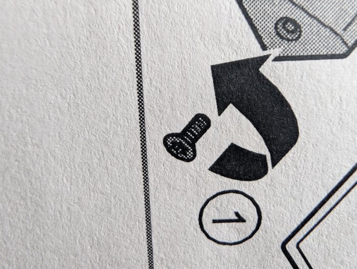 Illustration av en skruv med en böjd pil, hämtad från en manual, med siffran "1" i en cirkel till höger.