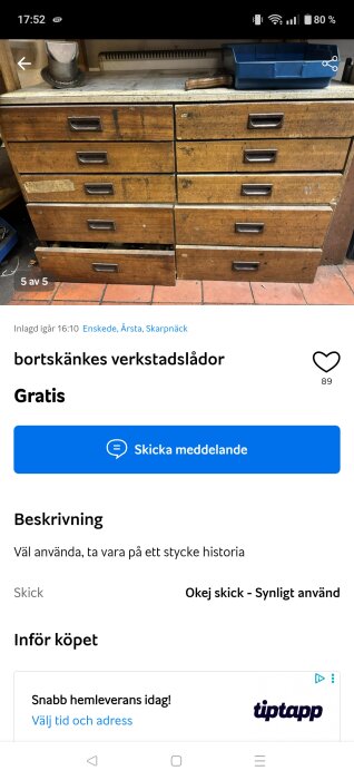 Träverkstadslådor med metallhandtag, viss slitage syns. På toppen en metallbit och plastlåda. En låda är lite utdragen. Står på ett klinkergolv.