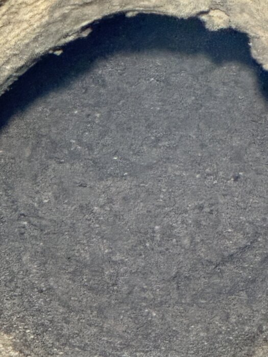 Hål i marken där berg syns i botten, tagen under en ny borrning 20 meter väster om tidigare plats.