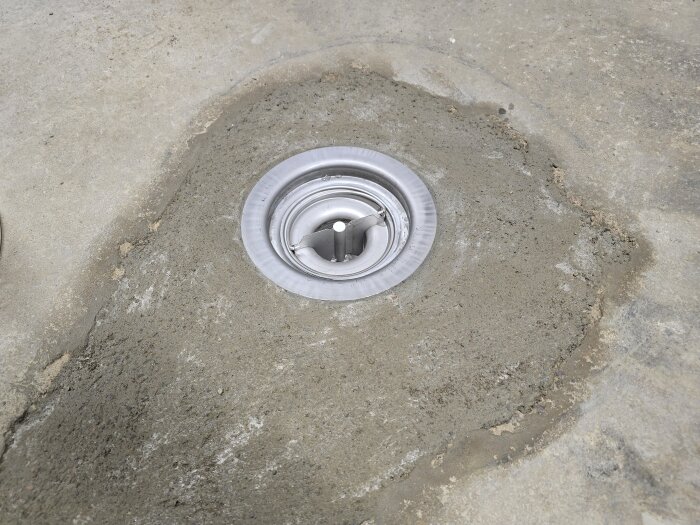 Gjutning av garagegolv kring nyinstallerad golvbrunn.