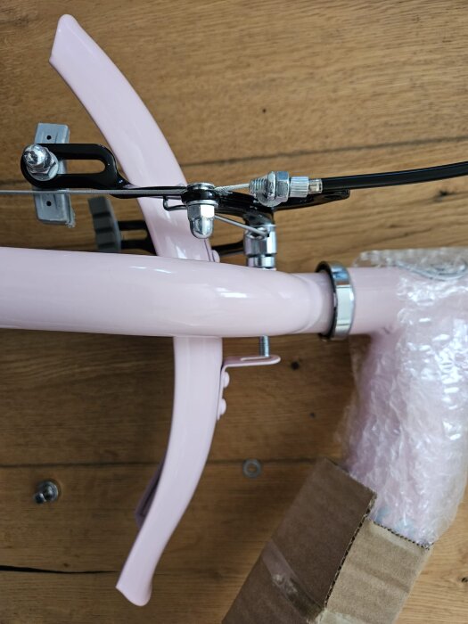 Cykelstänkskärm i rosa som försöks monteras, skruven når inte skärmen.