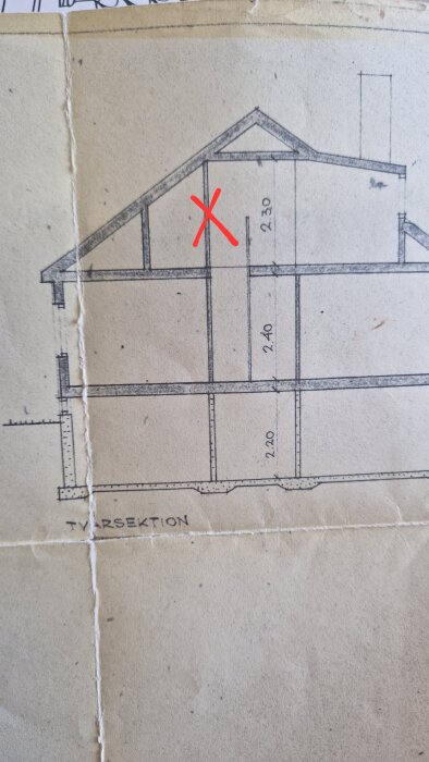 Ritning av hus med övervåning. En vägg har markerats med ett rött kryss för eventuell rivning, misstänkt vara icke-bärande.