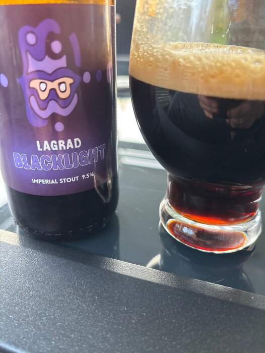 Flaska och glas med mörk imperial stout öl, etiketten säger "Lagrad Blacklight" med en alkoholhalt på 9,5 procent.