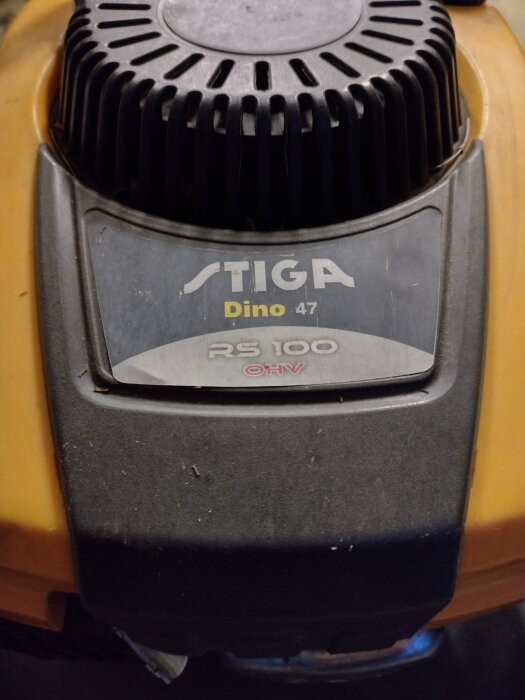 Närbild av en Stiga Dino 47 gräsklipparmotor med RS 100 OHV-märkning, del av ett gör-det-själv-reparationsprojekt.