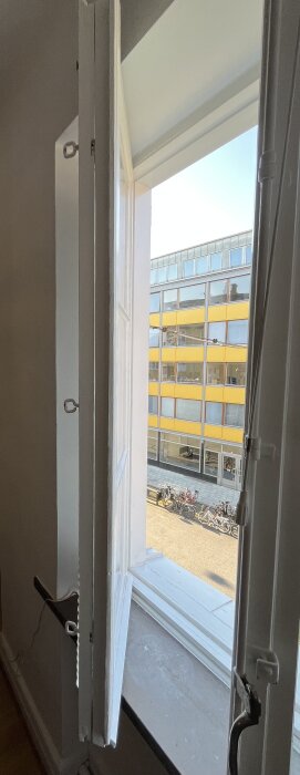 Träfönster placerade mot livlig gata, visar tvåglasfönster öppna inåt som en bok.