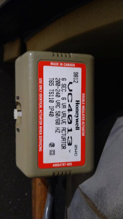 Honeywell VC4013 ventilaktuator i beige, med etikett och teknisk information synlig. Produkten är märkt "Made in Canada".