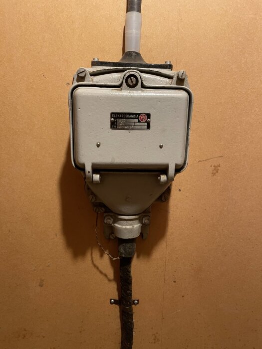 Elektrisk skåp från Elektroskandia monterat på en vägg, med rör och kablar synliga.