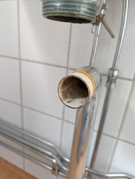 Anslutning mellan avloppsrör och vattenlås under en tvättställ i ett badrum, där en tätning verkar saknas.