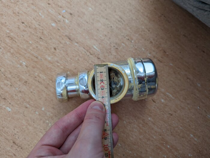 Uppmätning av avloppsrörsanslutning under tvättställ för att hitta rätt tätning i badrummet.