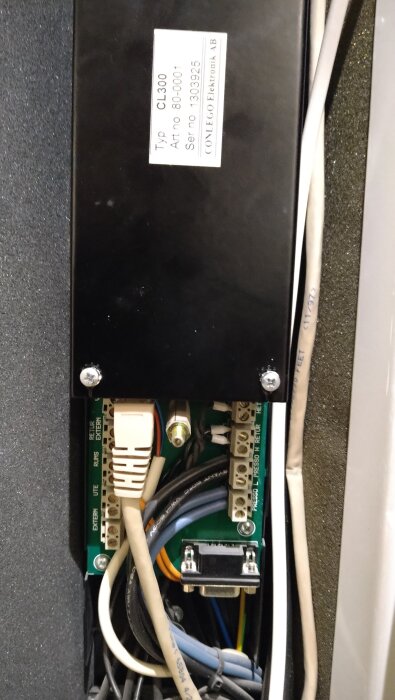 Kontrollmodul med etikett "Typ CL300" och diverse kablar kopplade till anslutningar, inklusive en com-port.