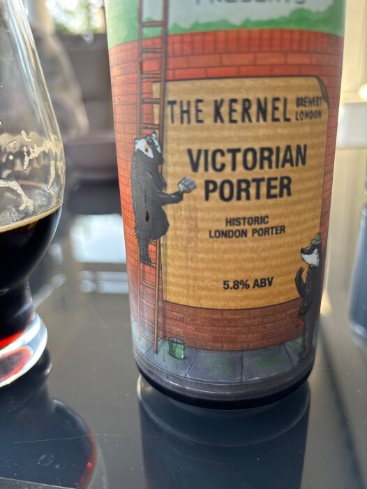 Flaska med etiketten "The Kernel Victorian Porter" och ett glas öl på ett bord.