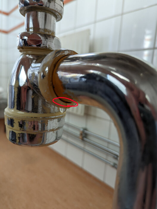 Kromad vattenkran med rost på muttern som läcker vid markerad cirkel.