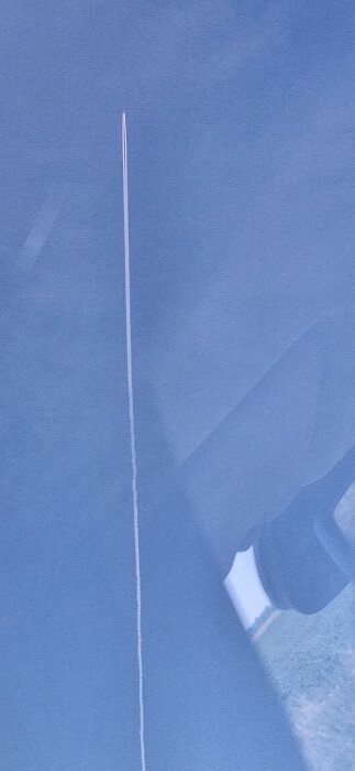 Flygplan lämnar ett rakt vitt kondensspår mot en klarblå himmel.